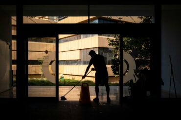 Professional cleaner from Mindful Cleaning Services meticulously cleaning a commercial building entrance in Morris County, NJ.