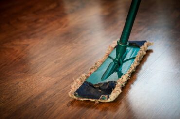 A professional cleaner from Mindful Cleaning Services meticulously mopping a floor in a Morris County, NJ office building.