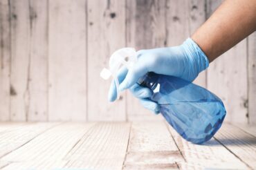 A professional cleaner from Mindful Cleaning Services sprays a non-toxic cleaning solution onto a countertop in a Boonton, NJ home.